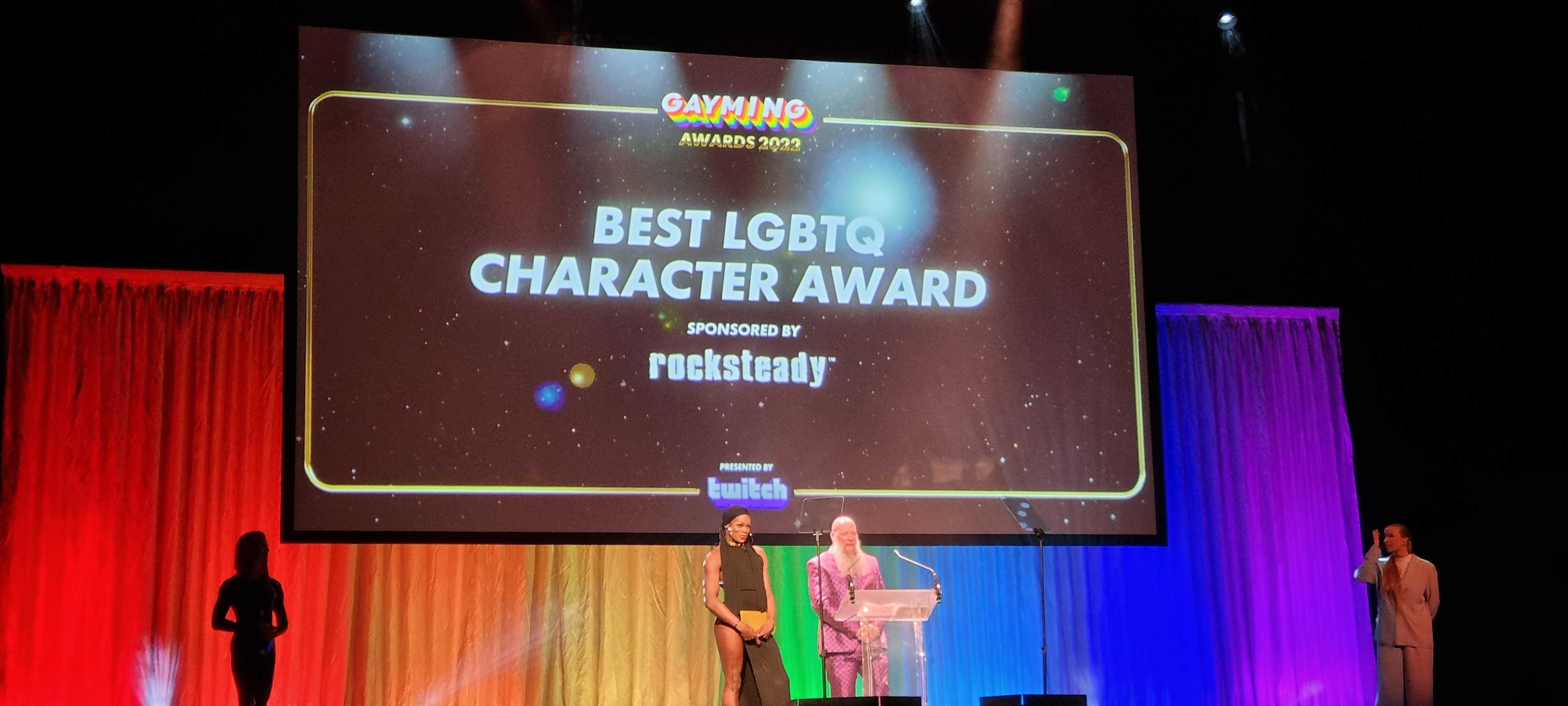 Photo of Rocksteady’s Advanced VFX Artist, Hanno Hinkelbein, on stage to present the Best LGBTQ Character Award for the Gayming Awards 2022.